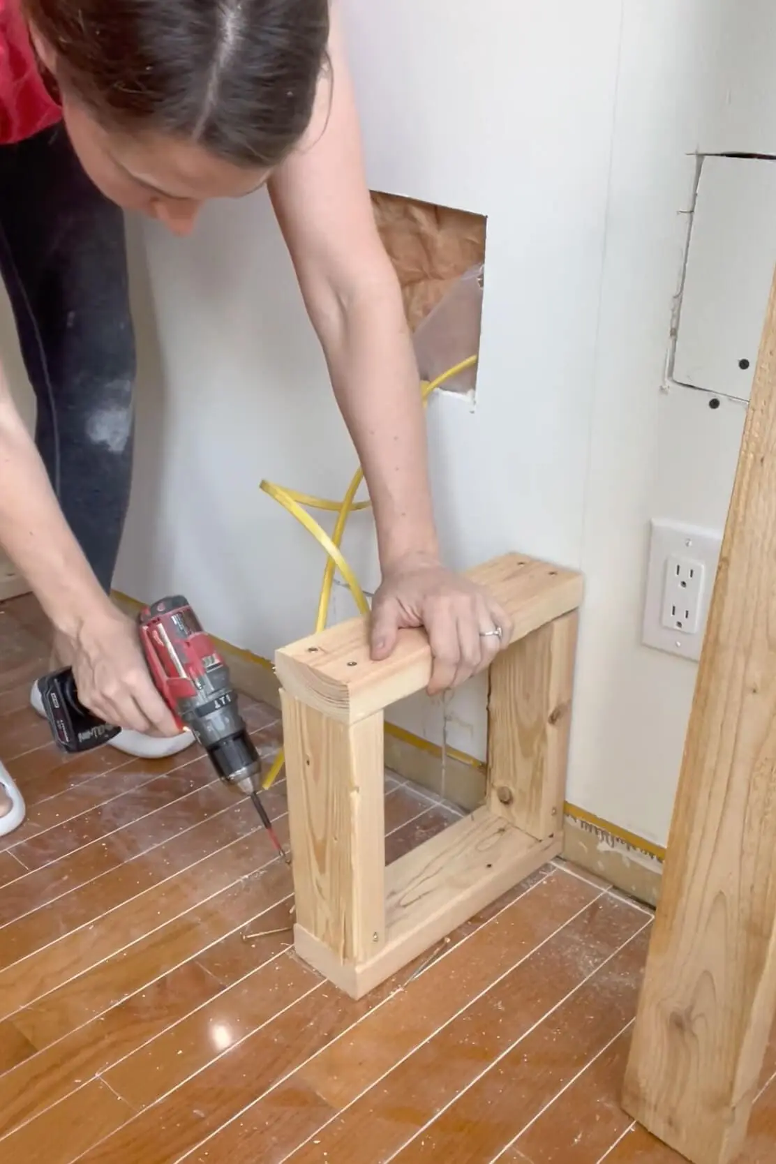 Building a base platform using 2x4s for the start of the DIY fireplace frame.